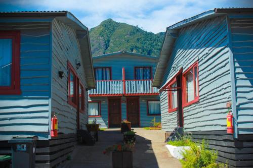 una fila de casas con montañas en el fondo en Cabanas L'ESCALE en Coñaripe