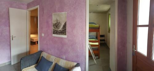 ein Zimmer mit einer lila Wand mit einem Sofa und einem Spiegel in der Unterkunft Au Coeur Des Ecrins in LʼArgentière-la-Bessée