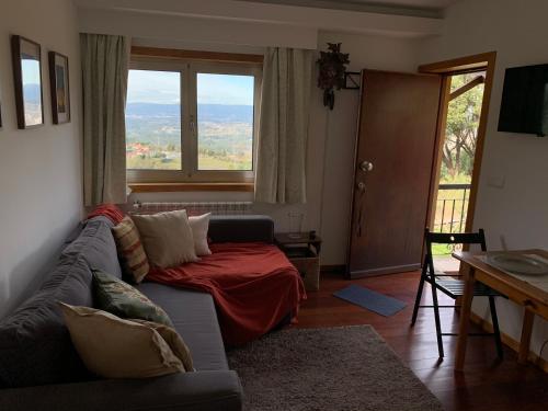 a living room with a couch and a large window at Cavado's heights Braga in Braga