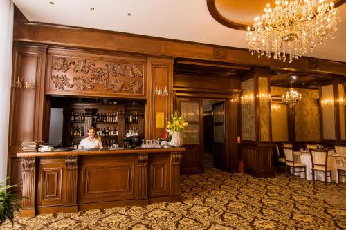 a woman standing at a bar in a restaurant at Hotel Balada in Suceava