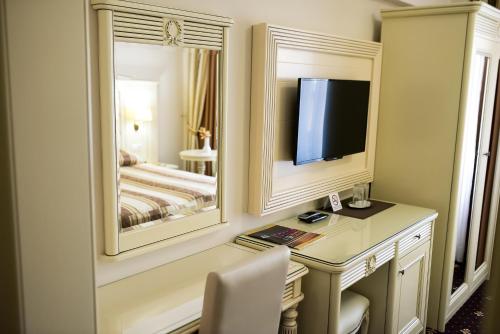 a bedroom with a desk and a mirror and a bed at Hotel Balada in Suceava