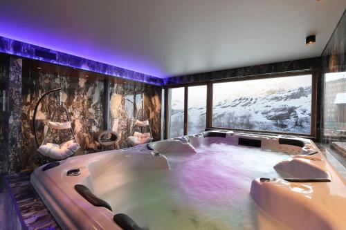 a large bath tub in a room with a large window at Chalet Blanc in Breuil-Cervinia