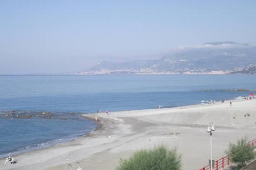a beach with people on the sand and the water at Hotel Piccolo Paradiso in Bordighera