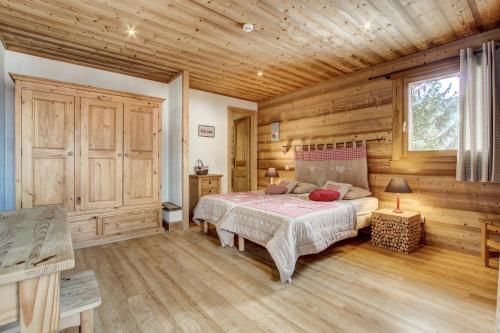 モルジヌにあるChalet Chez Nousの木製の壁のベッドルーム1室(ベッド1台付)