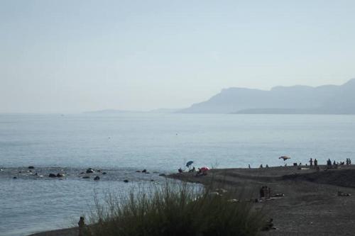 a group of people on a beach near the water at Hotel Piccolo Paradiso in Bordighera