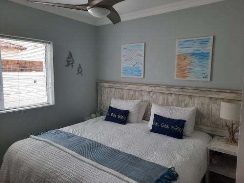 a bedroom with a bed with blue pillows and a ceiling fan at Heavenly Breeze in Hermanus