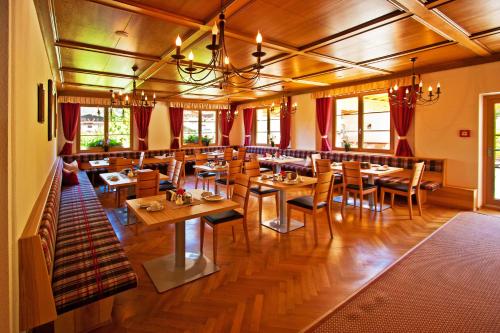comedor con mesas y sillas de madera en Landhotel Rauchenwalderhof en Mayrhofen