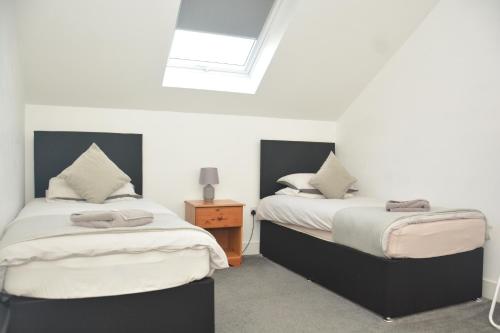 a bedroom with two beds and a skylight at Apartment 4 Biddicks Court in St Austell