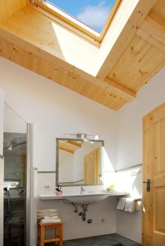 a bathroom with a sink and a skylight at Singerhof in Castelrotto
