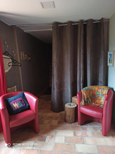 twee stoelen en een tafel in een kamer bij Les Granges De Cassard in Anglars
