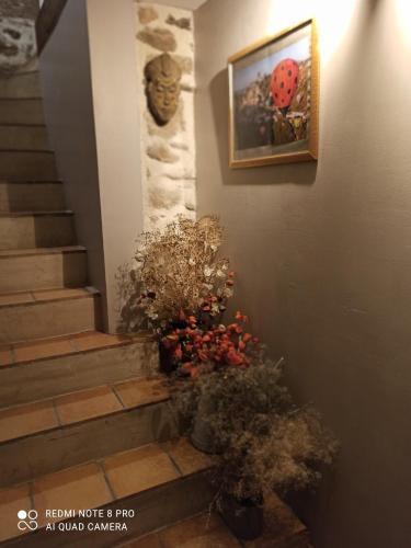 una escalera con flores y un cuadro en la pared en Les Granges De Cassard en Anglars