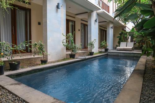 a swimming pool in front of a house at Alia Home in Sanur