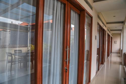 a hallway with sliding glass doors and a table at Alia Home in Sanur