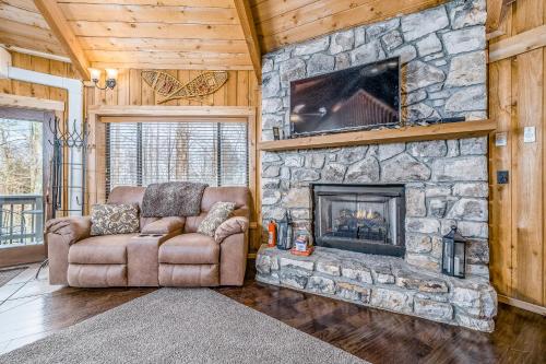 a living room with a stone fireplace and a couch at 135 Village Cluster in Beech Mountain