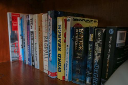 a row of books sitting on a book shelf at Alia Home in Sanur