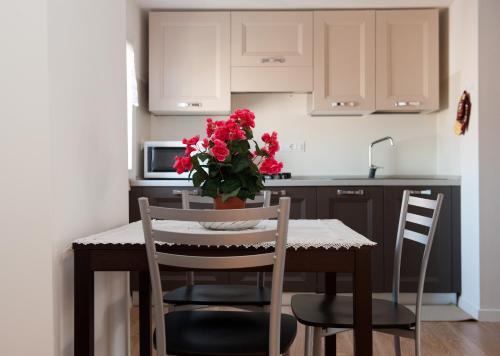 una cucina con tavolo e vaso di fiori rossi di Ca Palazzo a Venezia