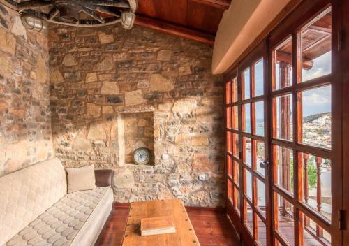 a living room with a couch and a stone wall at Elounda Traditional Homes of Crete in Elounda