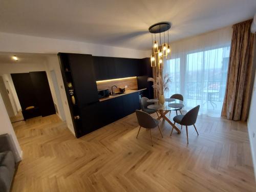 Panoramic Apartments Oradea في أوراديا: غرفة طعام وغرفة معيشة مع طاولة وكراسي