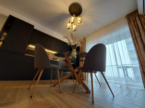 a dining room with a table and two chairs at Panoramic Apartments Oradea in Oradea