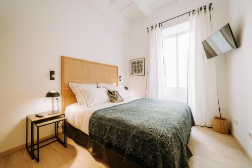 a bedroom with a bed and a large window at Hotel Artemisia in Ciutadella