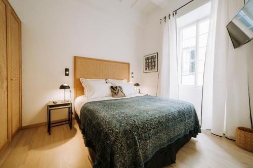 a bedroom with a large bed and a window at Hotel Artemisia in Ciutadella