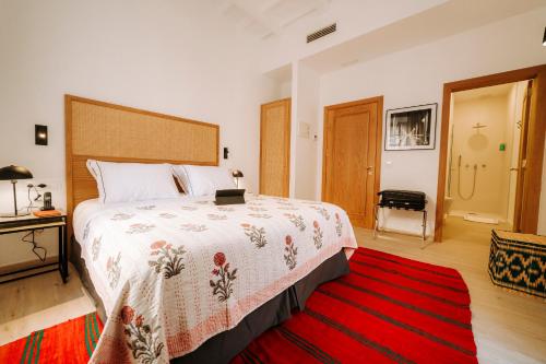 a bedroom with a large bed and a red rug at Hotel Artemisia in Ciutadella