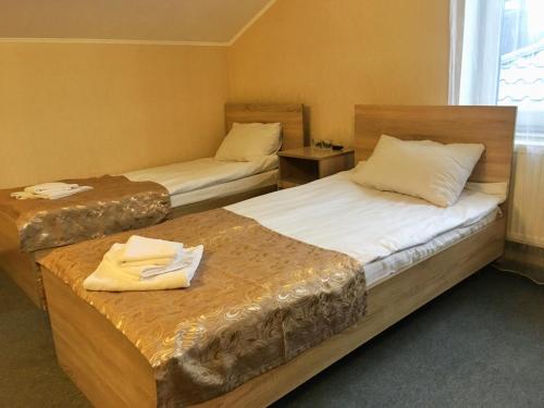 two beds in a hotel room with towels on them at Guest House SOTNI in Kyiv