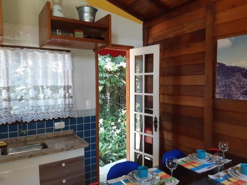 cocina con mesa y ventana en Chalezinho Pedra Azul, en São Pedro da Serra