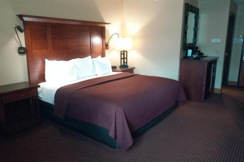 a bedroom with a large bed with a wooden headboard at Timberlake Lodge in Grand Rapids