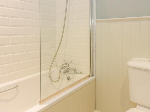 a bathroom with a shower with a sink and a toilet at East Cottage - Tarvit in Cupar