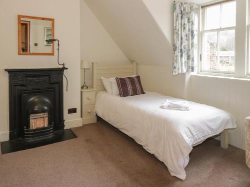 a bedroom with a bed and a fire place at Harmony Cottage - Harmony Gardens in Melrose