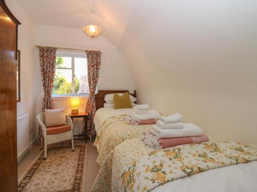 a bedroom with two beds and a window at Branklyn Garden Cottage in Perth