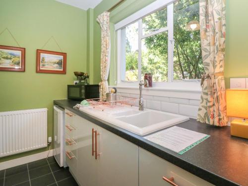 a bathroom with a sink and a window at Branklyn Garden Cottage in Perth