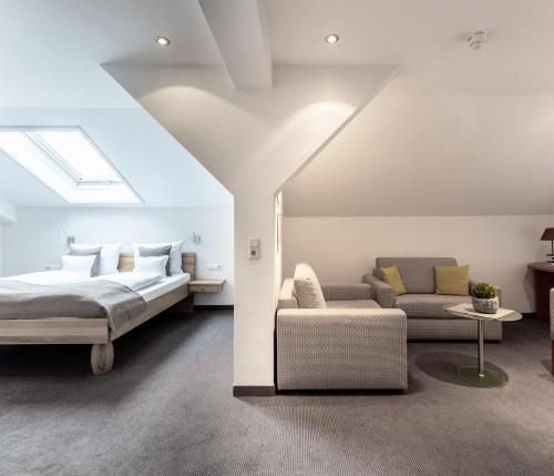 a bedroom with a bed and a couch at Hotel Zum Ochsen in Schonwald im Schwarzwald