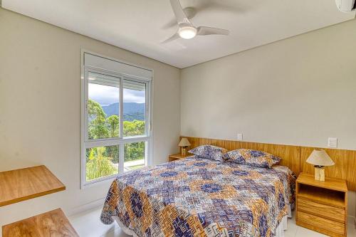 una camera da letto con un letto e una finestra di A23 - Conforto junto a natureza - Praia de Camburyzinho a São Sebastião