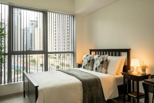 a bedroom with a bed and a large window at HiGuests - Cozy Studio with Jaw-Dropping Marina Views in Dubai