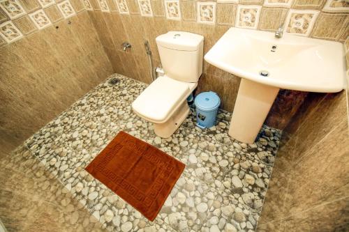a bathroom with a toilet and a sink at Yala New Nehansa Resort in Tissamaharama
