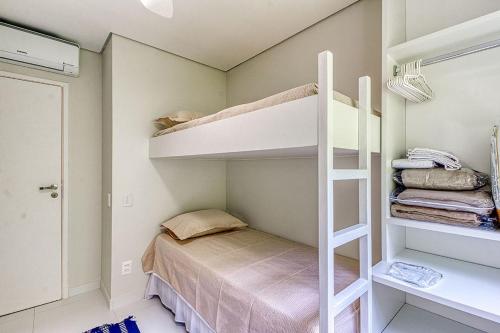 a small bedroom with a bunk bed and a ladder at C14 - Conforto junto a natureza - Praia de Camburyzinho in São Sebastião