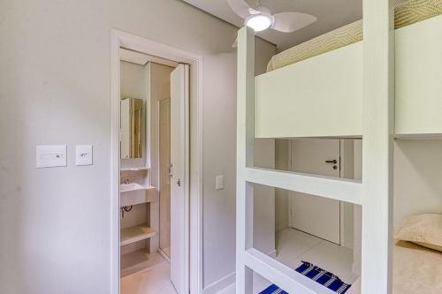 um quarto com armários brancos e um espelho em C14 - Conforto junto a natureza - Praia de Camburyzinho em São Sebastião