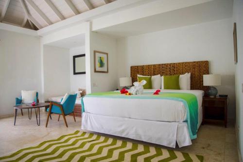a bedroom with a large bed and a table and chairs at Bequia Plantation Hotel in Bequia