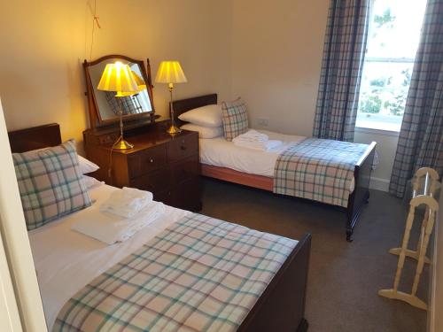 a hotel room with two beds and a mirror at Royal Artillery Cottage - Culzean Castle in Maybole