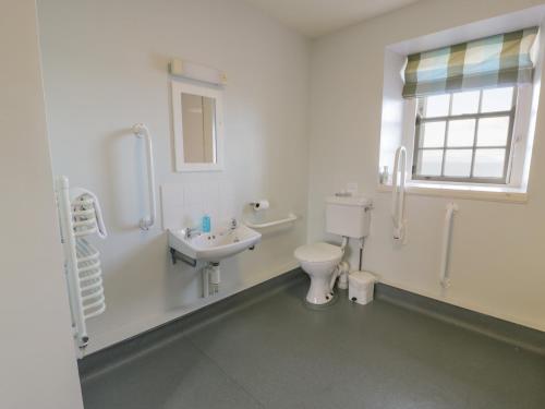 a white bathroom with a toilet and a sink at Royal Artillery Cottage - Culzean Castle in Maybole