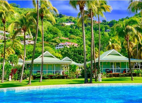 un complejo con palmeras y piscina en Bequia Plantation Hotel en Bequia