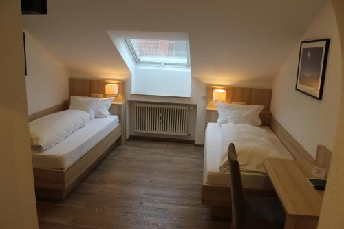 two beds in a small room with a window at Gasthof und Pension zum Löwen in Hirschberg an der Bergstraße