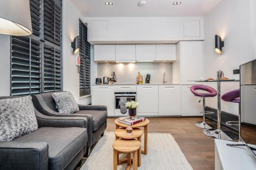 a living room with a couch and a table at Stay Kula London - Covent Garden Garrick St in London