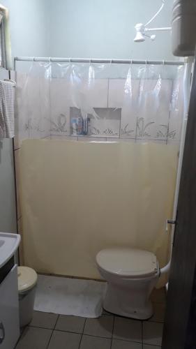 a bathroom with a toilet and a shower curtain at Magistério para veraneio e descanso in Pinhal