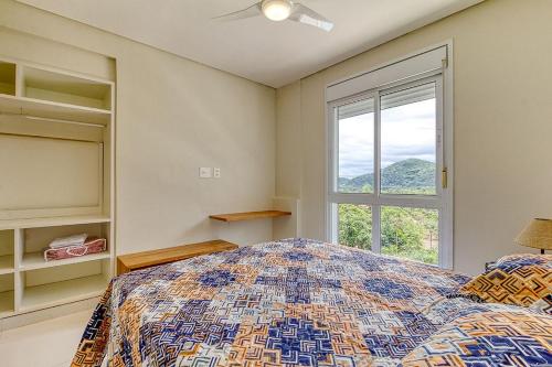 聖塞巴斯蒂安的住宿－D16 - Conforto junto a natureza - Praia de Camburyzinho，一间卧室设有一张床和一个窗口