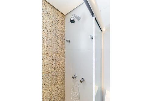 um chuveiro com uma porta de vidro na casa de banho em D16 - Conforto junto a natureza - Praia de Camburyzinho em São Sebastião