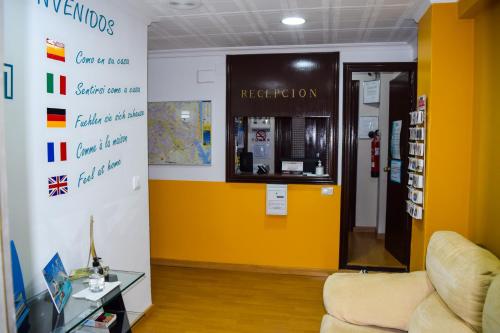 a waiting room with a yellow wall and a yellow door at Pension Waksman in Valencia