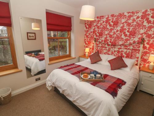 a bedroom with a bed with a tray of food on it at Losehill View in Castleton